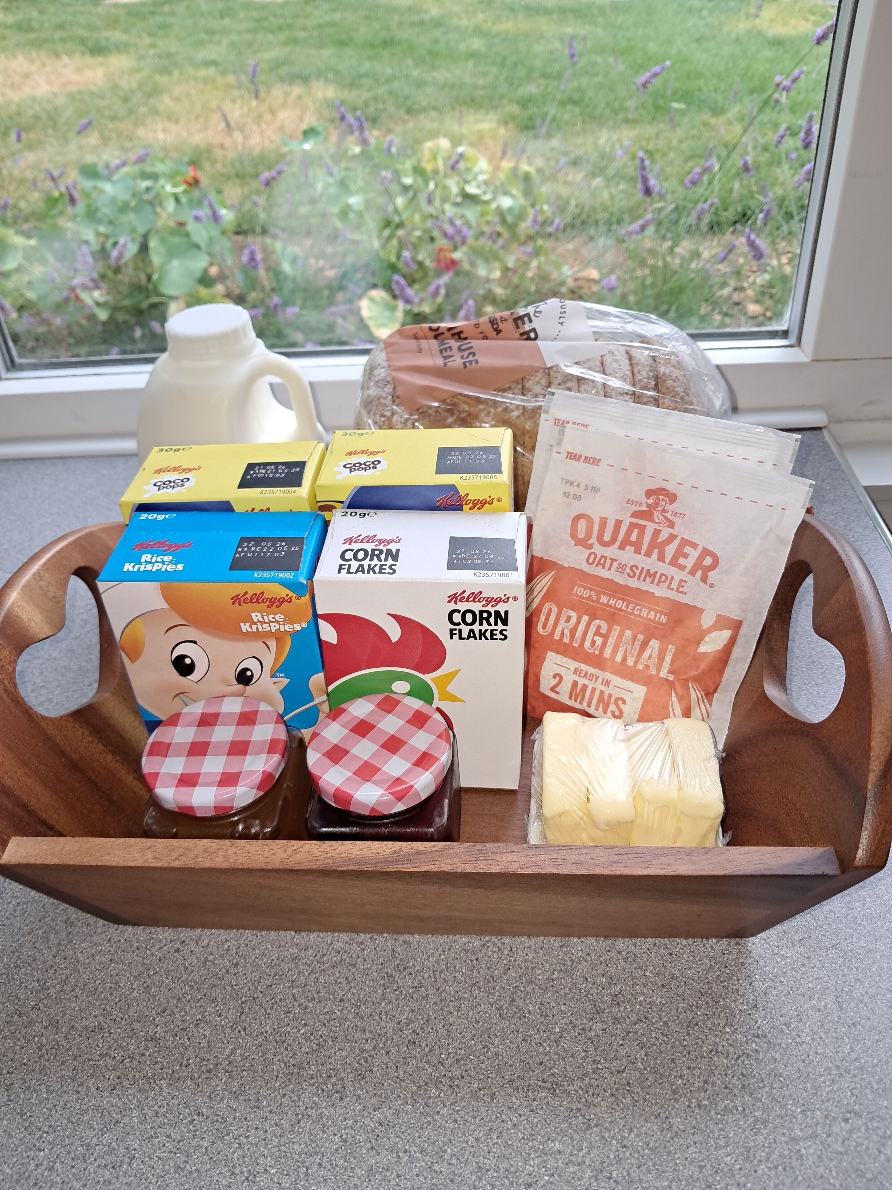 A tray with various food items including cereal boxes, a jug, and a package of butter.