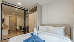 Une chambre d’hôtel avec un lit, un bureau et une chaise.