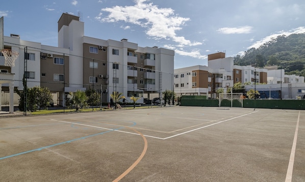 An outdoor basketball court surrounded by residential buildings.