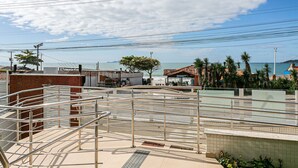A coastal hotel with a metal staircase, tiled walkways, and a view of the sea. - Modern ap W/pool one Block From the Beach Rmi201 (Florianópolis)