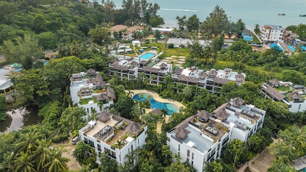 A resort with multiple buildings, a central swimming pool, and lush greenery surrounding the area. - C215 Bang Tao Beach Garden F21 (Choeng Thale)