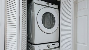A laundry room with two stacked washers and dryers.