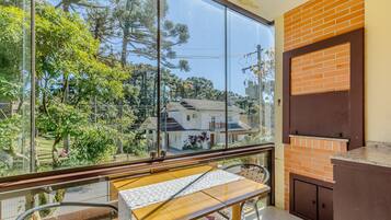 Uma varanda com vista para uma casa e árvores.