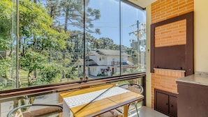 Un balcon donnant sur une maison et des arbres.