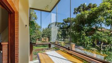 Varanda com vista para um jardim e árvores.