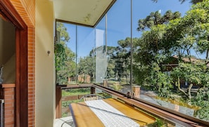 Een balkon met uitzicht op een tuin en bomen.