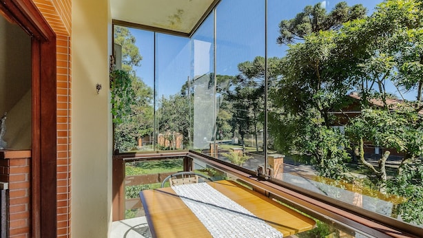 Un balcon donnant sur un jardin et des arbres.