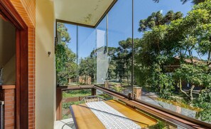 Ein Balkon mit Blick auf einen Garten und Bäume.