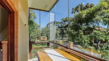 A balcony with a view of a garden and trees.