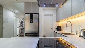 A modern kitchen with a built-in stove, stainless steel appliances, and a sleek countertop. - Modern apt With Pool and hot Tub! Rhl0305 (Florianópolis)