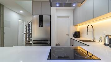 A modern kitchen with a built-in stove, stainless steel appliances, and a sleek countertop.