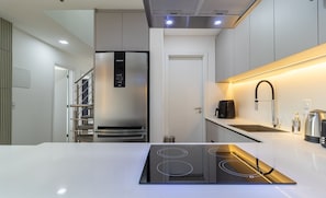 Una cocina moderna con estufa integrada, electrodomésticos de acero inoxidable y una encimera elegante.