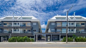 A modern building with a flat roof, multiple balconies, and a covered entrance. - Modern apt With Pool and hot Tub! Rhl0305 (Florianópolis)