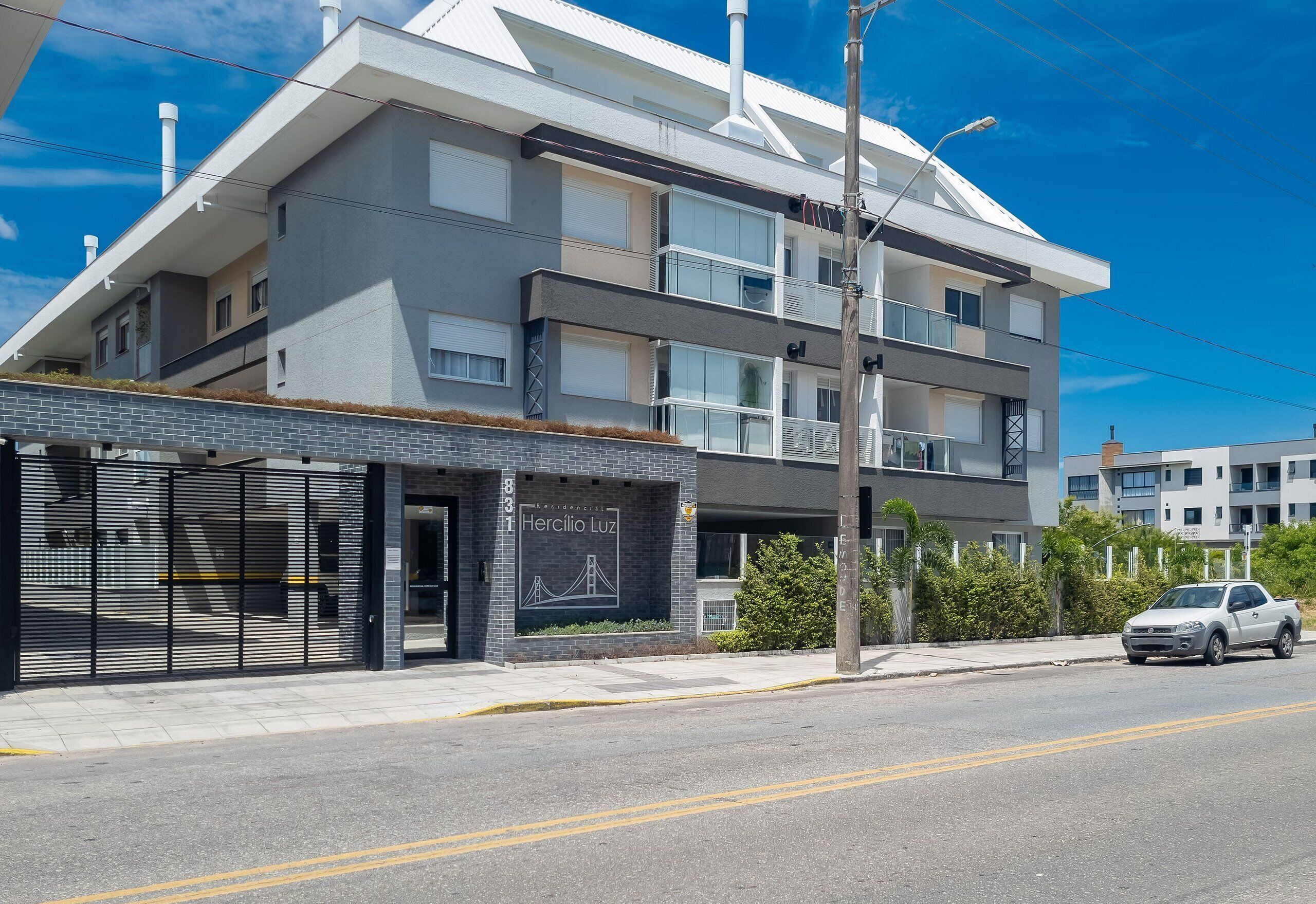 A modern multi-story building with a flat roof and large windows.