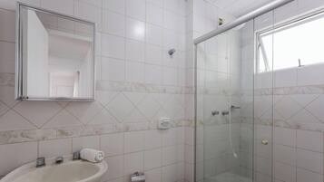 Un baño con lavabo, espejo y ducha.