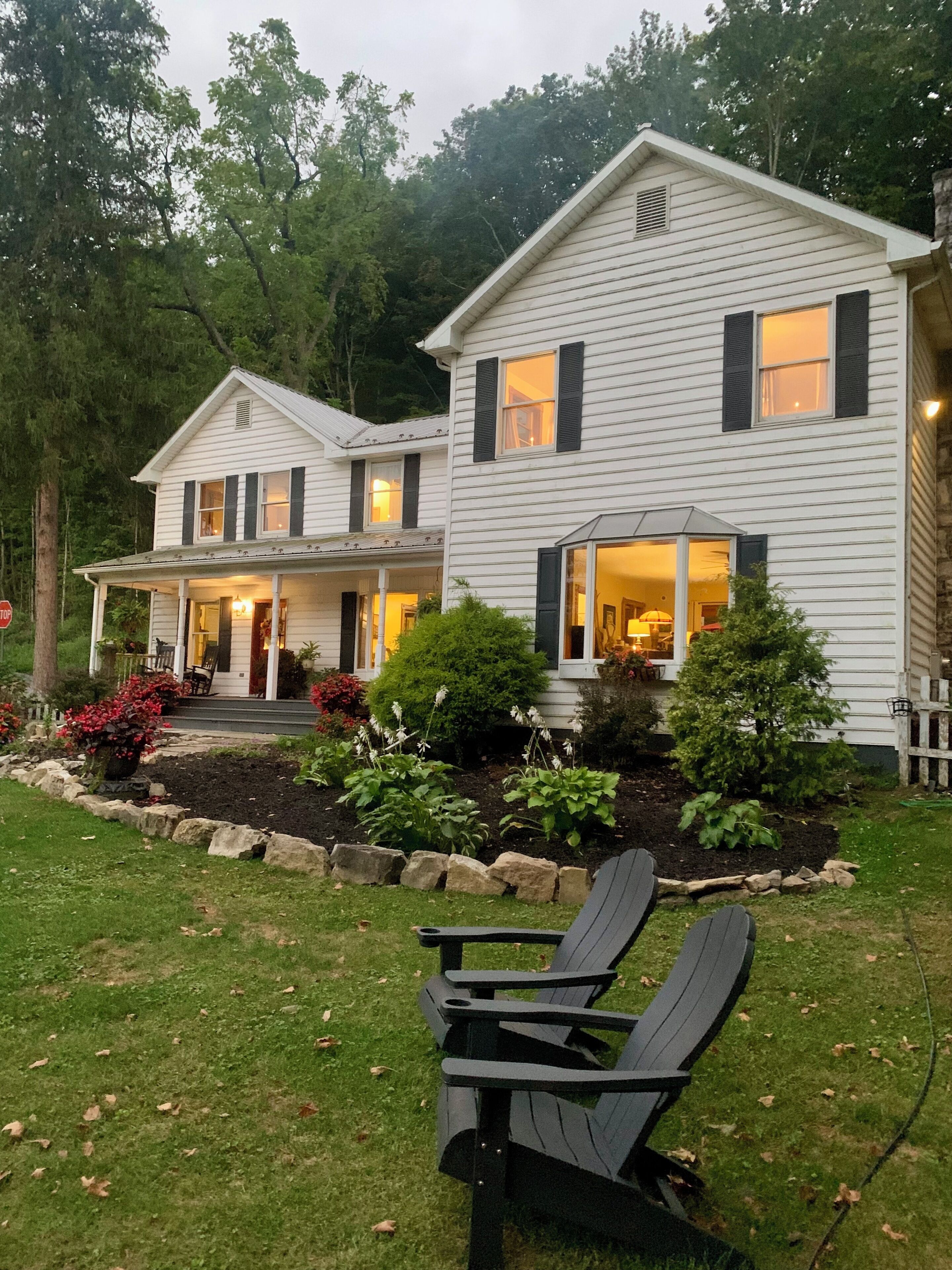 A two-story house with a porch and a garden.