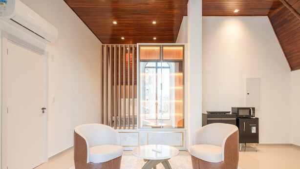 A modern room with two sofas, a small round table, a built-in TV, and a sliding glass door leading to a balcony. - Full Studio 650m From Meia Praia Rgor0025 (Itapema)