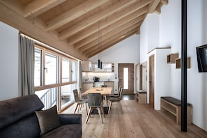 A modern interior with a dining area, wooden ceiling, and large windows.