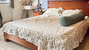 Un dormitorio con una cama de madera, un tocador con espejo y una pared con diseño.