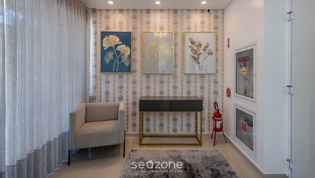 Een moderne woonkamer met een bank, een console tafel en decoratieve muurkunst.