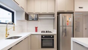 Een moderne keuken met een roestvrijstalen koelkast, een inbouwoven en een magnetron.