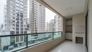 A balcony with a glass railing overlooking a cityscape of high-rise buildings. - Apt w/ Balcony & Bbq, 650m to Beach Rgo0502 (Itapema)