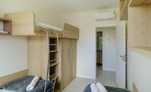A compact bedroom with a bunk bed, a wardrobe, and a bathroom visible through an open door. - Apt w/ Side sea View, Seaside Condominium Rap0306 (Florianópolis)