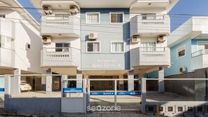 A residential building named 'Aguas Claras II' with multiple balconies, air conditioning units, and a gated entrance. - Beautiful Apt With BBQ 850m From the Beach Ral204 (Florianópolis)