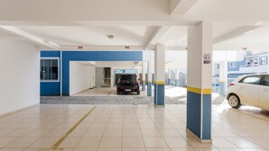 A parking garage with a blue and white color scheme, featuring numbered parking spots and a car parked in one. - Beautiful Apt With BBQ 850m From the Beach Ral204 (Florianópolis)