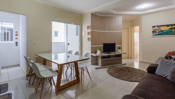 Una sala de estar moderna con comedor, televisor de pantalla plana y sofá.