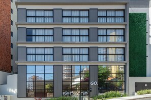 A multi-story building with large windows and a green wall. - Comfort With Pool in Pocos de Caldas Pgo412 (Poços de Caldas)