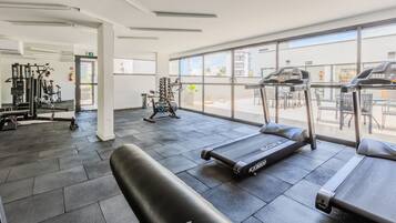 A gym with treadmills, exercise bikes, and weight machines.