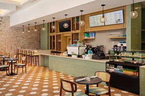 Ein Café mit Backsteinwand, Holztresen und einem hexagonal gemusterten Boden.