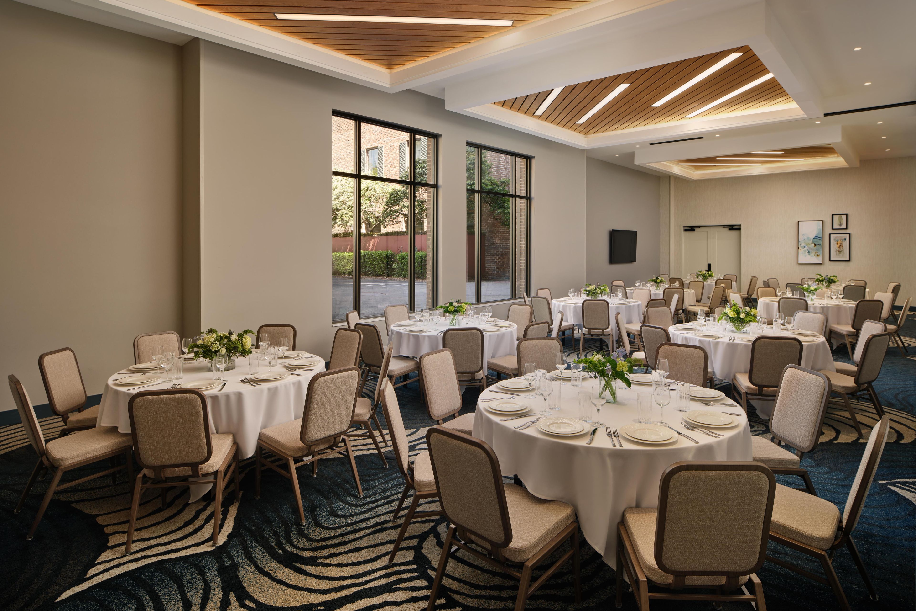 A conference room with multiple round tables, chairs, and a zebra-patterned carpet.