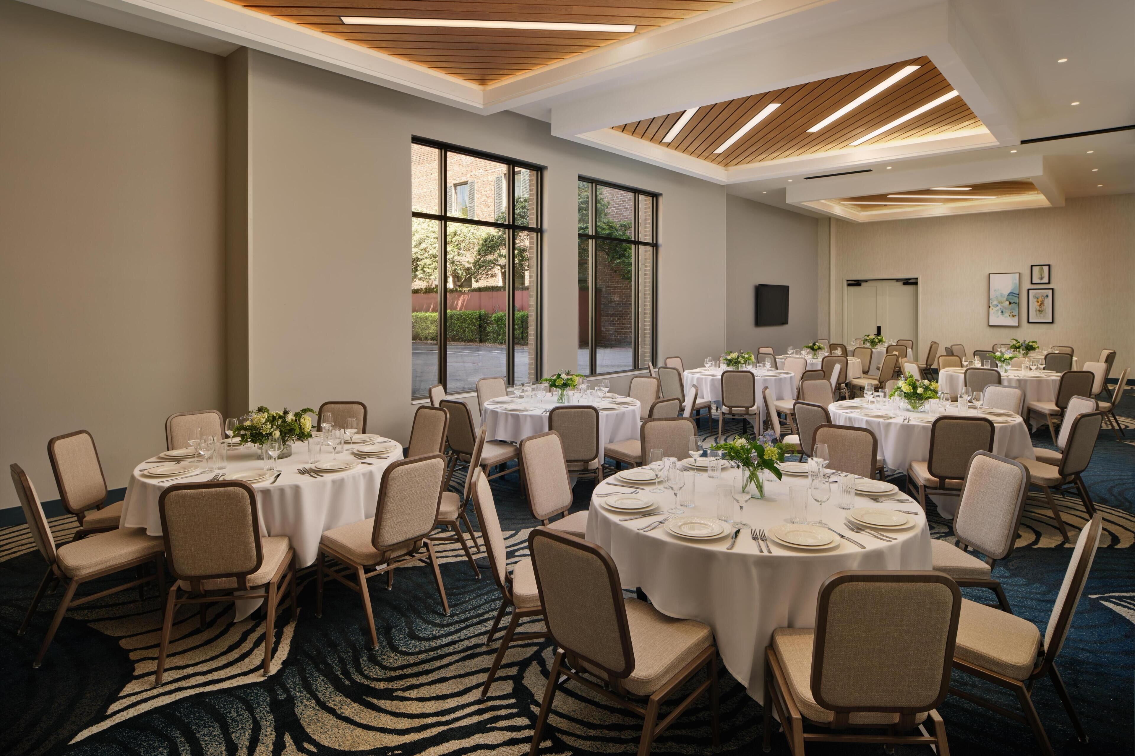 A conference room with multiple round tables, chairs, and a zebra-patterned carpet.