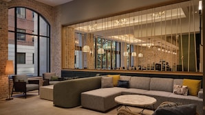 A modern living room with a sectional sofa, a round coffee table, and a wicker chair.