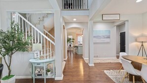 Un interior espacioso con una escalera, un comedor y una cocina.