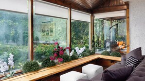 Una habitación con techo de madera, ventanas amplias, un banco y un sofá.