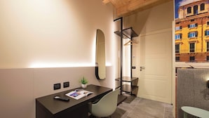 A modern hotel room with a desk, chair, and a large mirror. There is a small plant on the desk and a door leading to another room. - Italian flat - Verona's River (Verona)