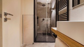 A modern bathroom with a glass shower enclosure, a wooden vanity, and a wall-mounted towel rack. - Italian flat - Verona's River (Verona)