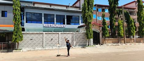 A building with a sign that reads 'RESTAURANT' on the facade.