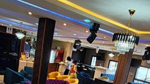 A hotel lobby with colorful armchairs, a marble coffee table, and a chandelier. - NEWTOWN PALACE HOTEL (Garoua)
