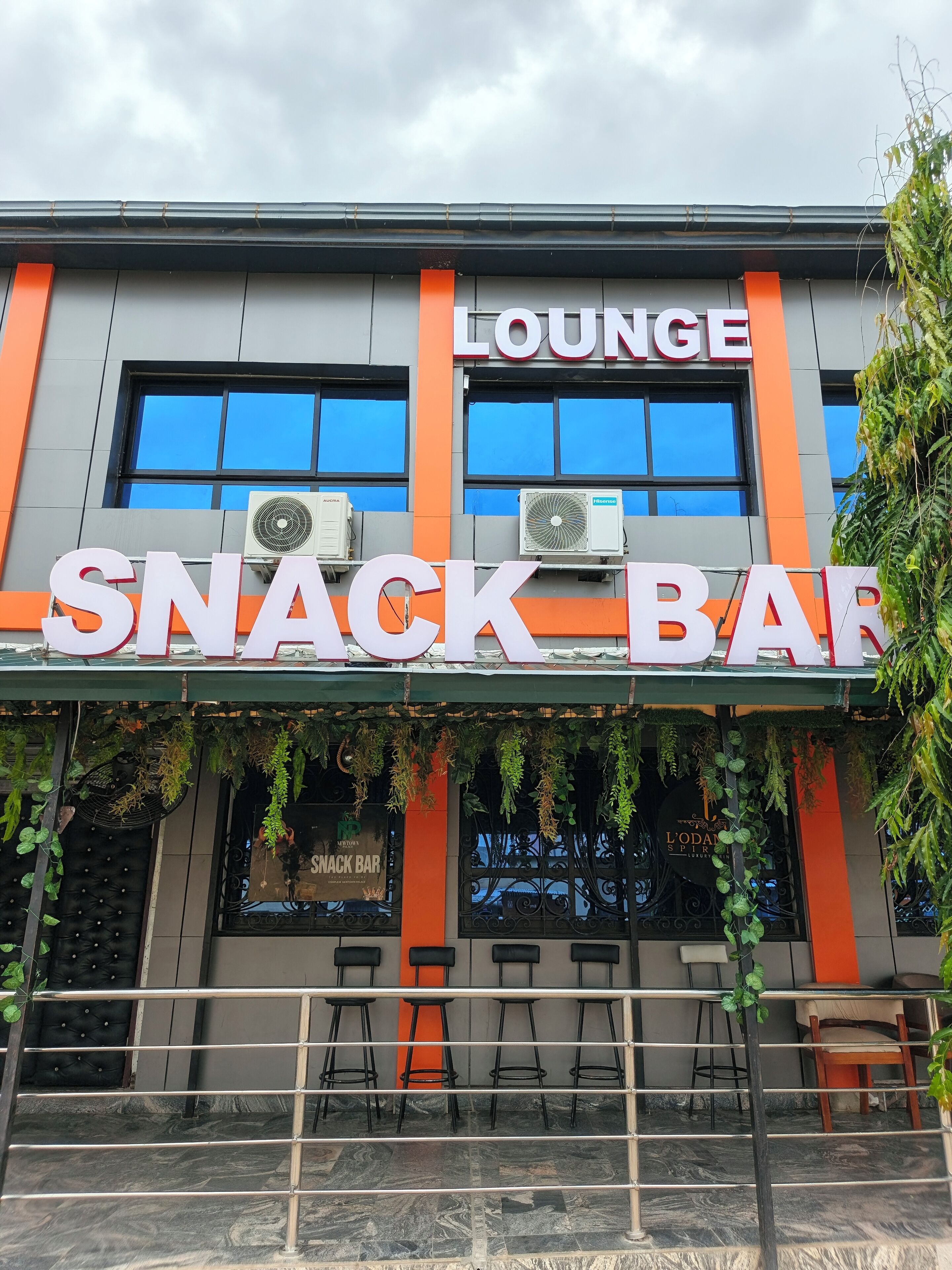 A snack bar with a lounge area, air conditioning units, and outdoor seating with a railing.