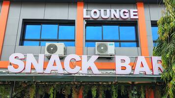A snack bar with a lounge area, air conditioning units, and outdoor seating with a railing.