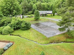 An aerial view of a large, open parking area surrounded by lush greenery and trees.