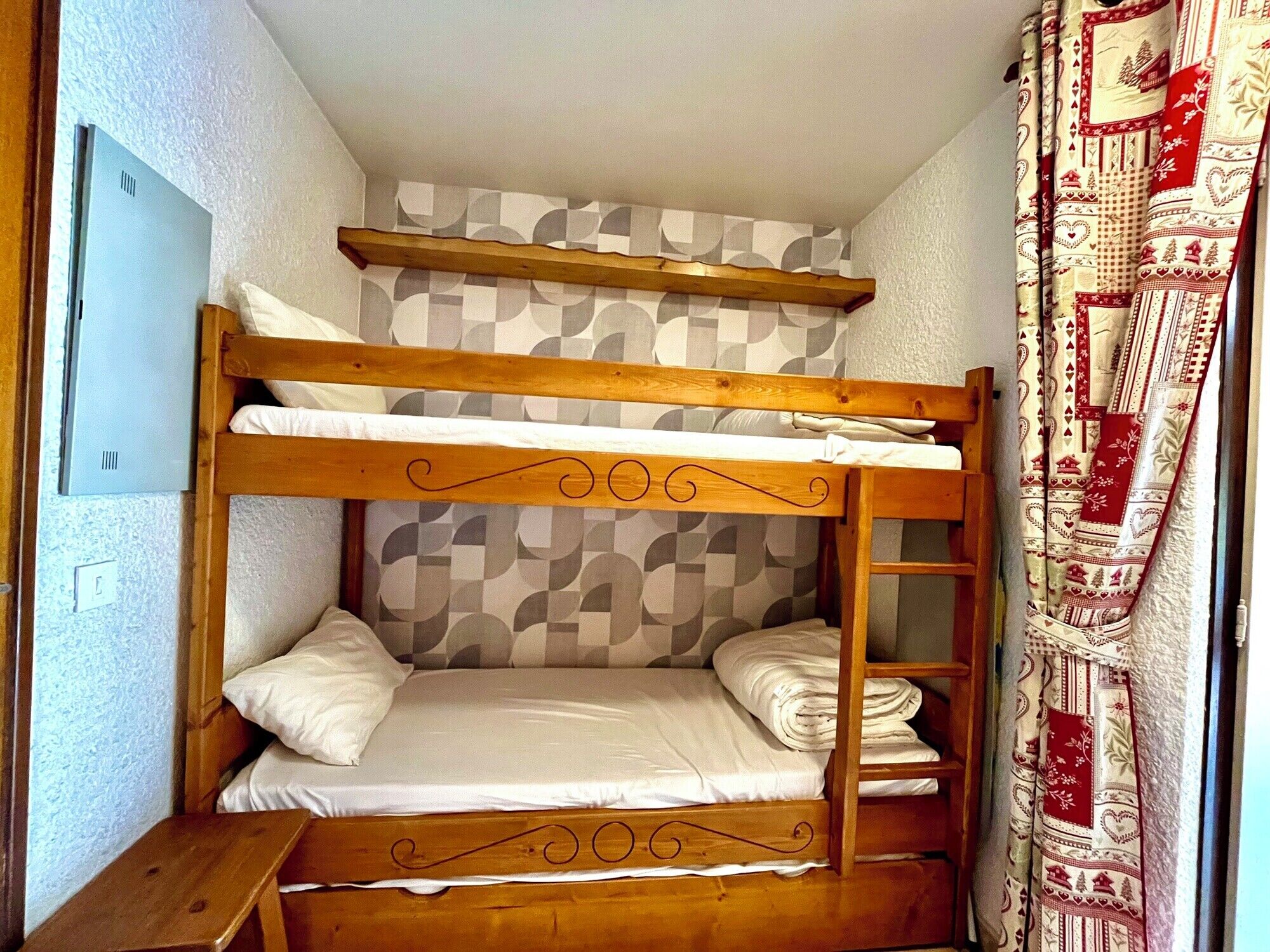 A bunk bed with a geometric-patterned wall behind it.