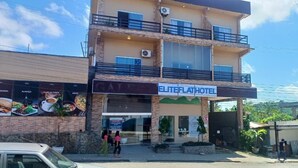 Un edificio de dos pisos con un cartel que dice 'ELITEFLAT HOTEL'.