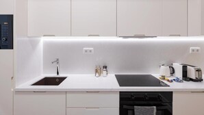 Una cocina moderna con un lavaplatos empotrado, cafetera, tostadora y hervidor.