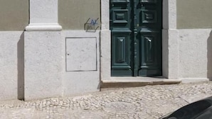 A building with a green door marked "CM1910" and the number "28" above it.