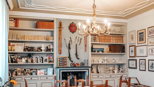 A dining room with a chandelier, wooden chairs, a patterned floor, and shelves with books and decorative items. - Casa Eda, in the green hills of Lucca and 5 minutes from the historic center (Lucca)